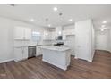 Bright kitchen features white cabinetry, stainless steel appliances, granite countertops, and island at 728 Ben Ledi Ct, Raleigh, NC 27603