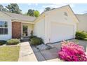 Front view of a charming home with a brick facade and a well-kept lawn leading to an attached two-car garage at 729 Golden Horseshoe Ln, Sanford, NC 27330