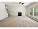 Spacious living room with a fireplace, large windows, carpet and a ceiling fan at 7425 Silver View Ln, Raleigh, NC 27613