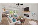 Open concept living room featuring sleek ceiling fan, fireplace, and seamless transition to kitchen at 811 Fargo St, Durham, NC 27707