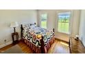 Bright bedroom featuring two windows and a colorful flower-patterned quilt at 84 Dogeye Rd, Benson, NC 27504
