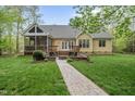 Landscaped backyard featuring a patio and path to the screened-in porch at 85 Rivers Edge Ct, Timberlake, NC 27583