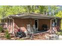 Brick back porch featuring rocking chairs, an ATV, and wrought iron details at 906 Circle Dr, Creedmoor, NC 27522