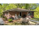 Brick porch featuring rocking chairs, ATV, wrought iron, and outdoor seating area at 906 Circle Dr, Creedmoor, NC 27522