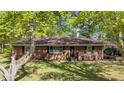 Inviting brick home featuring a cozy entrance and a well-manicured lawn, enhanced by the shade of mature trees at 906 Circle Dr, Creedmoor, NC 27522
