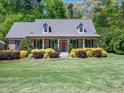 Beautiful home featuring a well-manicured lawn, brick exterior, a welcoming front porch and colorful front garden at 936 Elbridge Dr, Raleigh, NC 27603