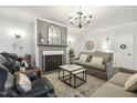 Cozy living room features a fireplace, elegant chandelier, and comfortable seating at 98 Buddy Campbell Ct, Angier, NC 27501