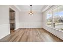 Bright dining room showcasing wood floors, a modern chandelier, and large picture windows at 000 Olivia Pope Way, Efland, NC 27243