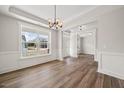 Open-concept dining room with hardwood floors and modern light fixture at 000 Olivia Pope Way, Efland, NC 27243