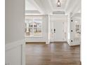 Light and airy foyer features pristine white walls, hardwood floors, and a charming entry door at 000 Olivia Pope Way, Efland, NC 27243