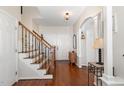 Warm and inviting foyer with hardwood floors and staircase with decorative iron railings at 101 Rustic Pine Ct, Apex, NC 27502