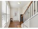 Inviting entryway with hardwood floors, staircase with decorative wrought iron spindles, and natural light at 1016 Mirbeck Ln, Durham, NC 27713