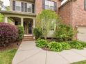 Beautiful home exterior with a brick facade, covered porch, lush landscaping, and a welcoming entrance at 111 Gathering Place Pl, Durham, NC 27713
