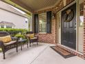 Inviting front porch with wicker furniture, a wreath, and a welcome mat, perfect for relaxing outdoors at 111 Gathering Place Pl, Durham, NC 27713
