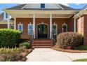 Close-up of a brick home's entrance featuring a covered porch with white columns and a double-door entrance at 121 Westchase Run, Sanford, NC 27330
