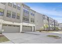 Modern gray townhome featuring a two car garage, gray siding, and a well manicured lawn at 1215 Corkery Ridge Ct, Cary, NC 27519