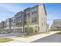 Modern gray townhome featuring a two car garage, gray siding, and a well manicured lawn at 1215 Corkery Ridge Ct, Cary, NC 27519