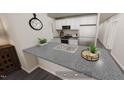 A modern kitchen with white cabinets, stainless steel appliances, and a spacious gray countertop with double basin sink at 123 Landon Pl, Roxboro, NC 27573