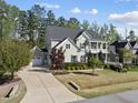 Beautiful two-story home with a long driveway, lush landscaping, and attached garage at 1305 Reservoir View Ln, Wake Forest, NC 27587