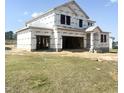 New construction home featuring a large attached garage with a covered front porch and a graded lawn at 139 Fast Pitch Ln, Four Oaks, NC 27524