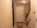 View of the home's entryway featuring a white door with cross, stairs, and tile flooring at 1505 Kendall Dr, Durham, NC 27703