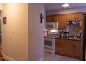 A spacious kitchen with wooden cabinets, white appliances, and decorative tile backsplash at 1505 Kendall Dr, Durham, NC 27703