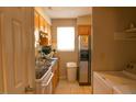 Galley kitchen featuring wood cabinets, stainless steel sink, and white appliances at 1505 Kendall Dr, Durham, NC 27703