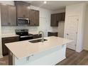 Modern kitchen with stainless steel appliances, dark cabinets and white countertops with a center island sink at 172 Parker Ln, Mebane, NC 27302