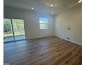 Bright, open living room features wood floors, large windows and glass sliding doors leading to the backyard at 172 Parker Ln, Mebane, NC 27302