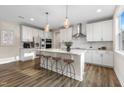 Modern kitchen boasts a spacious island with bar stools, stainless steel appliances, and ample counter space at 1809 Harrell Cove Ct Ct # 181 Gunnison Fc, Fuquay Varina, NC 27526