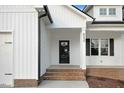 Charming entryway with detailed molding, black front door, and brick lined porch at 203 Sourgum Ct, Zebulon, NC 27597