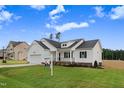 Beautiful one-story new construction home with a well-kept lawn, 'For Sale' sign, and attractive curb appeal at 203 Sourgum Ct, Zebulon, NC 27597
