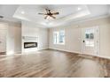Spacious living room with wood floors, a ceiling fan, and an electric fireplace at 203 Sourgum Ct, Zebulon, NC 27597