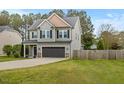 Attractive two-story gray home with a two-car garage, landscaped front yard and adjacent wooden fence at 218 Darecrest Ln, Wendell, NC 27591