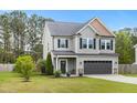 Well-maintained gray two-story home with a two-car garage, set against a backdrop of lush green trees at 218 Darecrest Ln, Wendell, NC 27591