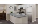 Bright kitchen featuring gray countertops, stainless steel appliances and white cabinetry at 224 Landon Pl, Roxboro, NC 27573