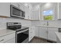 Close up of a kitchen featuring white cabinets, stainless steel appliances, quartz countertops, and subway tile backsplash at 241 Connelly Way, Zebulon, NC 27597