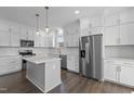 Modern kitchen featuring white cabinets, stainless steel appliances, and an island with white countertop at 241 Connelly Way, Zebulon, NC 27597
