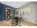 Eat-in kitchen has blue accent wall with views of the outside through a large window at 2808 Polesdon Ct, Raleigh, NC 27615