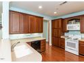 Well-equipped kitchen featuring classic wood cabinetry, modern appliances, and hardwood floors, perfect for culinary enthusiasts at 2813 Market Bridge Ln # 204, Raleigh, NC 27608