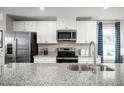 Modern kitchen with a stainless steel sink and sleek black appliances and granite countertop at 35 Boots Ridge Way, Franklinton, NC 27525