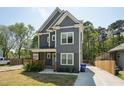 Charming two-story home with gray siding, white trim, covered porch, and a concrete driveway at 3908 Booker Ave, Durham, NC 27713