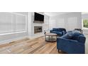 Cozy living room with hardwood floors, fireplace, television, and two blue sofas at 3908 Booker Ave, Durham, NC 27713