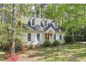 Charming cottage-style home with dormer windows, white shutters, and a landscaped front yard at 4 W Bridlewood Trl, Durham, NC 27713