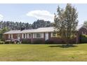 Brick ranch with large yard, white trim, metal roof, and tidy landscaping at 481 Firetower Rd, Louisburg, NC 27549