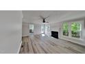 Spacious living room with a fireplace, ceiling fan, and lots of natural light at 4828 Forest Highland Dr, Raleigh, NC 27604