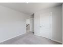 Neutral carpeted bedroom with doorways to hall, closet, and stairs at 51 Landon Pl, Roxboro, NC 27573