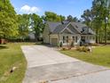 View of the home with a paved driveway leading to an attached garage at 6907 Field Hill Rd, Raleigh, NC 27603