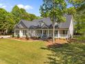 Spacious home featuring a lush green lawn and mature trees in a picturesque setting at 6907 Field Hill Rd, Raleigh, NC 27603