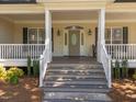 Inviting covered front porch features traditional railings and steps leading to a decorative glass front door at 6907 Field Hill Rd, Raleigh, NC 27603